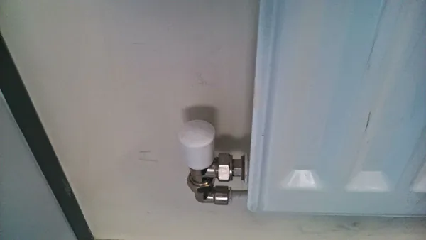 Radiator key opening a bleed valve on a home radiator