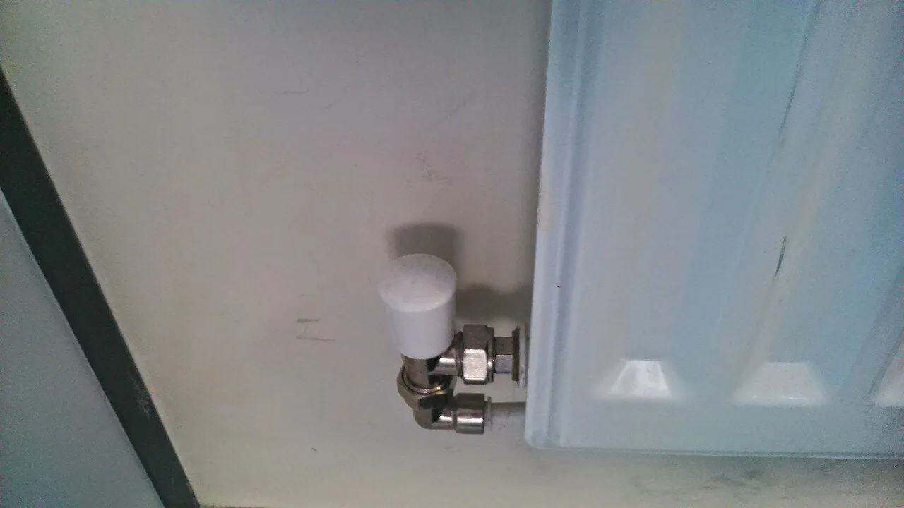 Radiator key opening a bleed valve on a home radiator